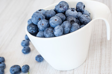 White bowl cup with fresh ripe blueberries