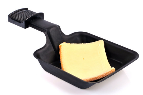 Morceau de fromage dans une pelle à raclette