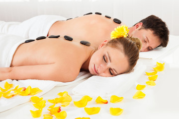 Couple having a hot stone massage - Powered by Adobe