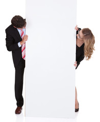 Professional man and woman with a blank sign