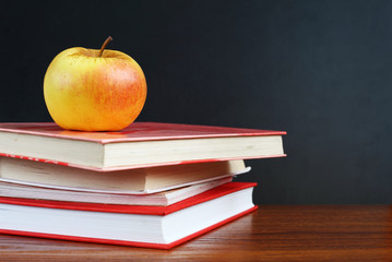 Back to school. Image of blank teacher's desk with a pile of tex