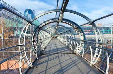 Steel and glass bridge for pedestrians crossing over the railway