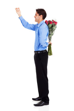 Young Man With Bunch Of Red Roses Knocking On The Door