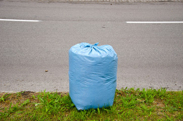 blue garbage bag on city street