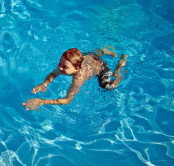 child swims in the pool