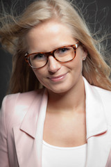 Blonde girl with long hair and glasses. Beauty studio shot.