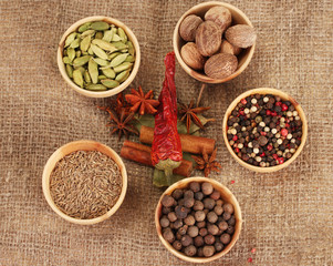Nutmeg and other spices on sackcloth background