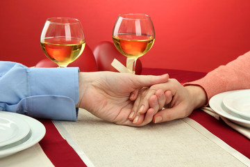 hands of romantic couple over a restaurant table