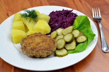 kotlet mielony z ziemniakami,ogórkiem i kapustą