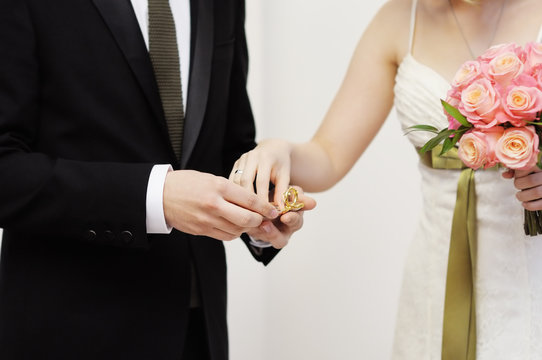 Bride holding ring during wedding ceremony