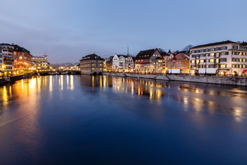 Fototapeta na wymiar Illuminated Cityhall i Limmat River Bank wieczorem, Zuric