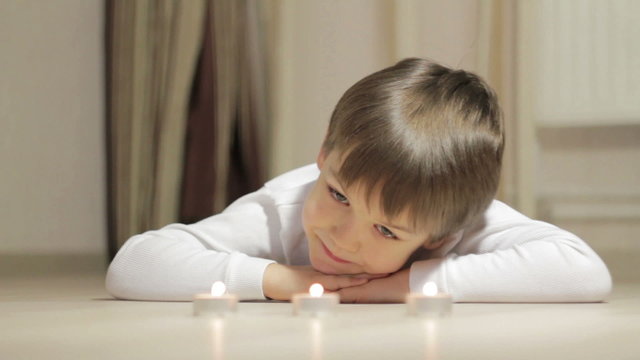 little boy looking at the candles