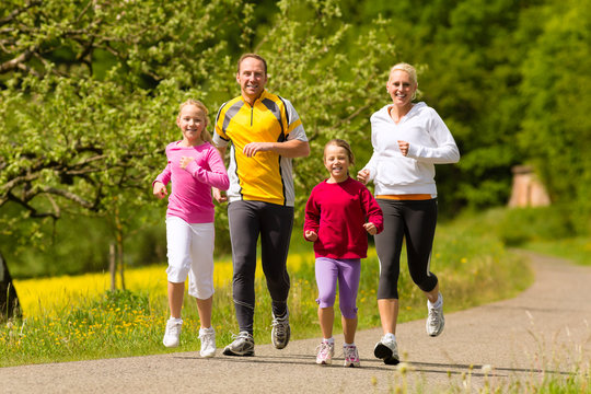 Family Running In The Meadow For Sport