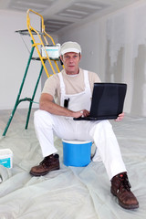 Painter taking a break to use his laptop