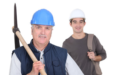 mature manual worker and young apprentice in background