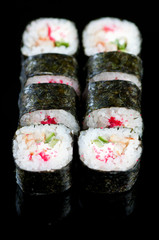 Set of Dragon rolls on a black plate, vertical shot