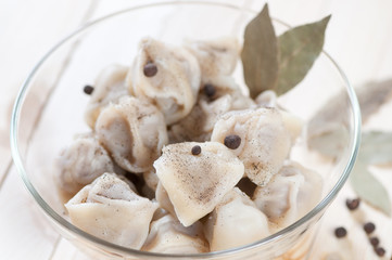 Russian cuisine: bowl of boiled pelmeni, studio shot