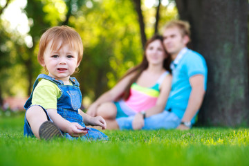 little baby with parents in a summer park. picnic