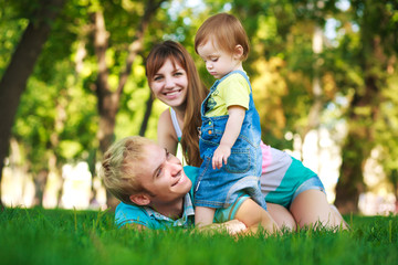 Naklejka na ściany i meble family on a green lawn in park