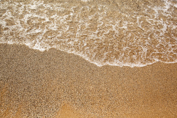 sea ​​caresses the sand on the beach