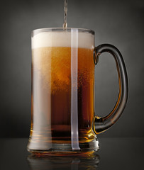 Mug of beer over black background