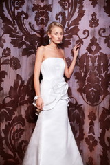 sexy blond bride in white wedding dress in interior