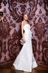 sexy blond bride in white wedding dress in interior