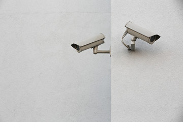 Two security cameras on a wall.