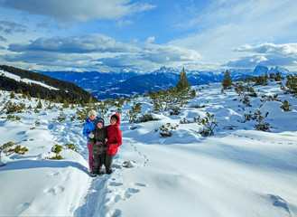 Family walking on winter mountain slope