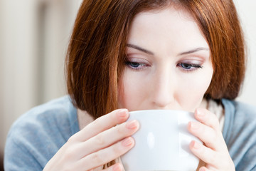 Woman with cup of tea has a rest at the cosy restaurant