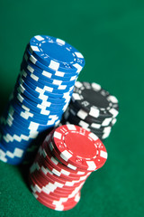 Piles of multicolored chips on the green poker table