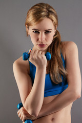junge ernste sportlerin mit fitness hanteln