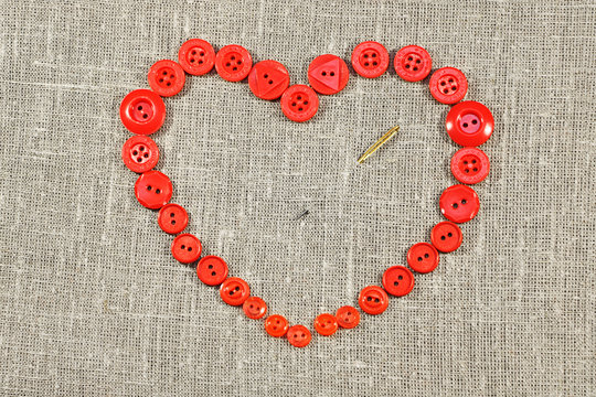 Heart of red buttons pierced needle