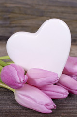 Herz mit rosa Tulpen auf Holz