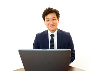 パソコンで仕事中の笑顔のビジネスマン