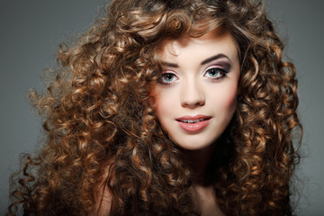 Fototapeta premium Young beautiful woman with long curly hairs