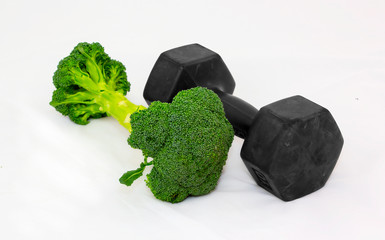 Dumbbell made of Broccoli on white background. Focus in front.
