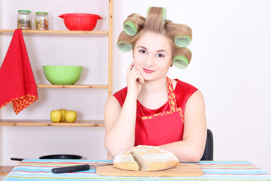 attractive housewife cutting bread in the kitchen