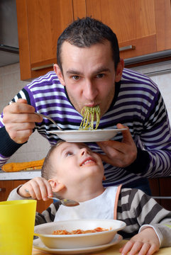Padre e hijo comiendo pasta,disfrutando.