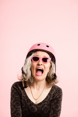 funny woman wearing Cycling Helmet portrait pink background real