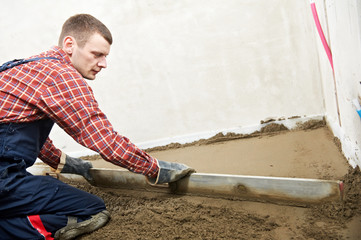 Plasterer concrete worker at floor work