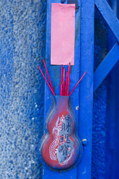 Red chinese incense put on blue door front of house
