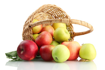 juicy apples with green leaves in basket, isolated on white