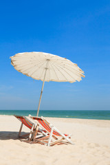 Colorful wooden beach chairs with sun umbrella