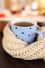 cup of tea with scarf on table in room