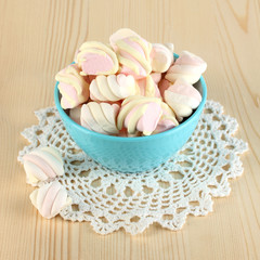 Gentle marshmallow in bowl on wooden table close-up