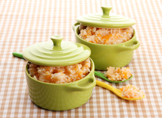 Taste rice porridge with pumpkin in saucepans