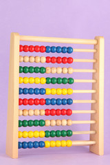 Bright wooden toy abacus, on purple background