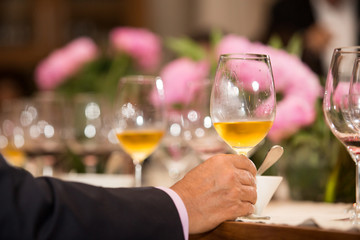 Hombre adulto cenando con una copa de vino dulce.