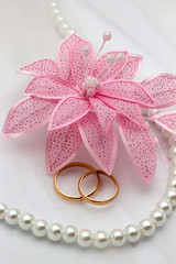 Flower and two gold rings on a wedding background